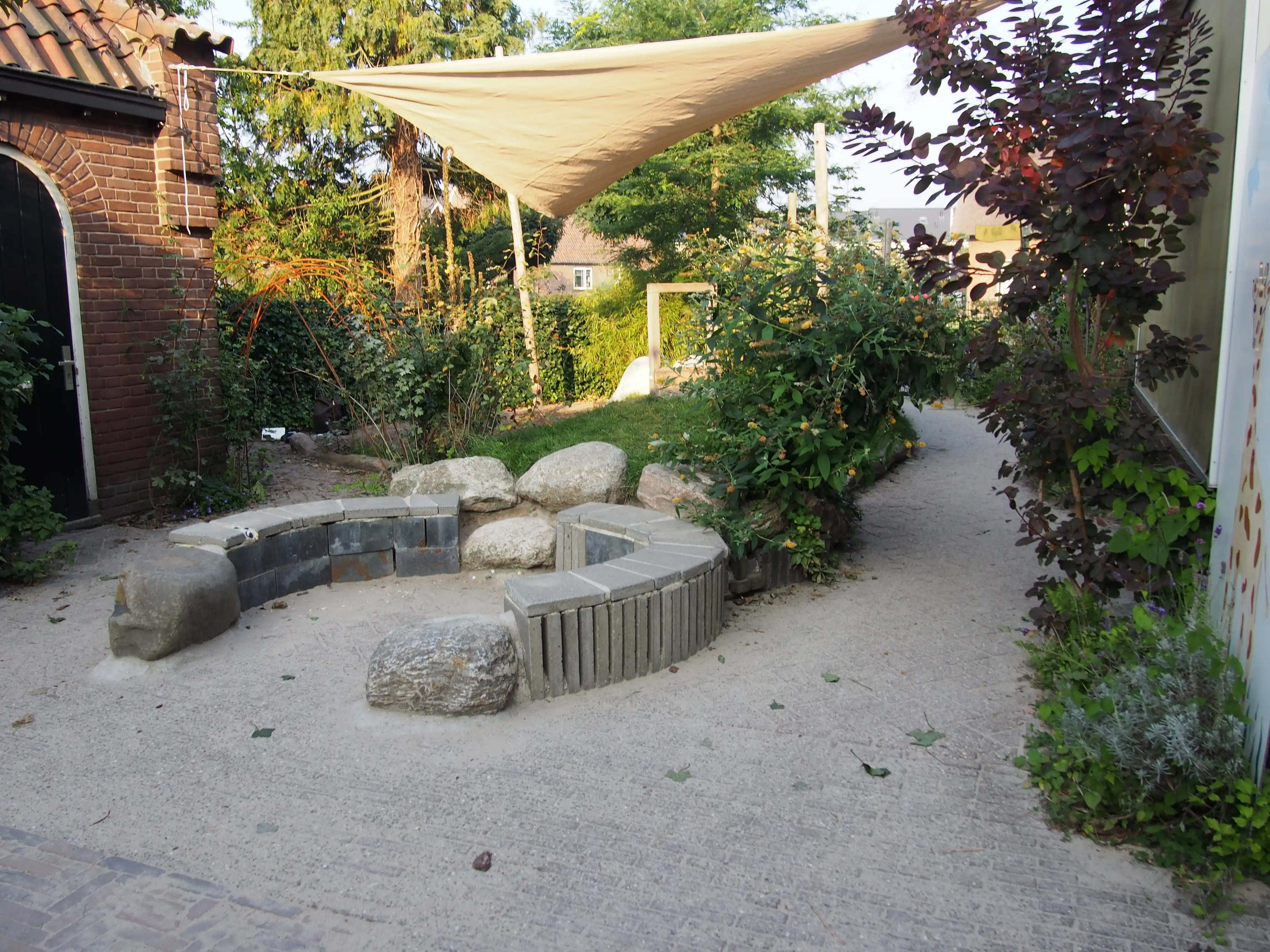 Zone de jeux avec voile d'ombrage et rochers